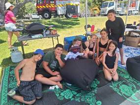A group of people sitting on a blanket

Description automatically generated